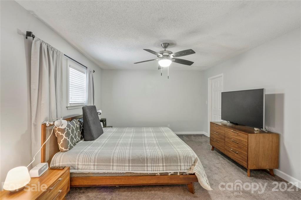 167 Mooreland Road, Unit 94 Mooresville, NC 28117 - Photo 14 of 34 a bedroom with a bed and tv with wooden floor