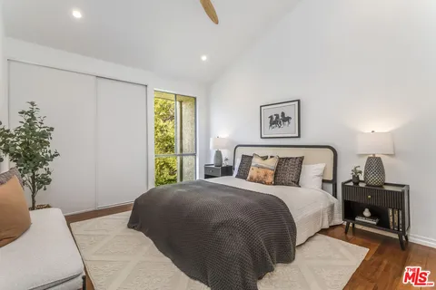 a bedroom with a large bed and a potted plant