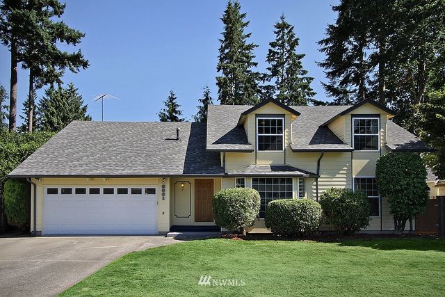 a front view of a house with a garden and plants