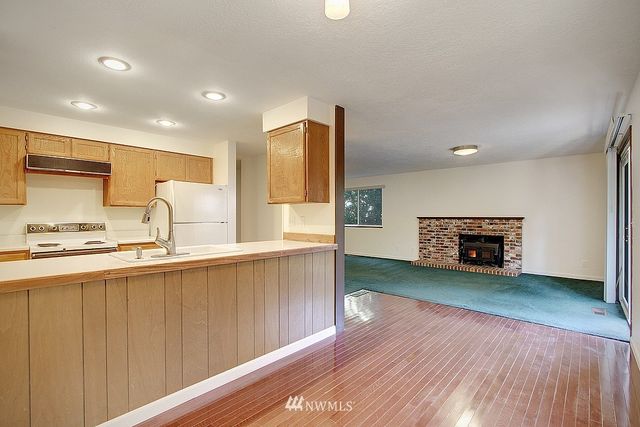 a kitchen with stainless steel appliances a sink cabinets and wooden floor
