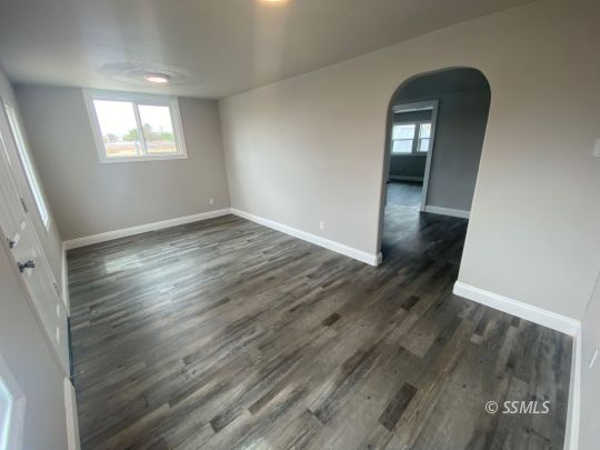 461 South Norma Street Ridgecrest, CA 93555 - Photo 5 of 17 an empty room with wooden floor and windows