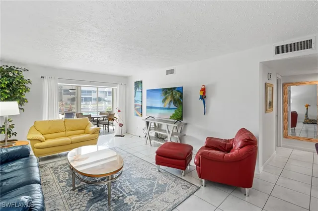 a living room with furniture a rug a window and a flat screen tv
