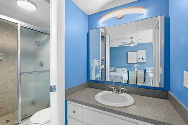a bathroom with a granite countertop sink toilet and shower