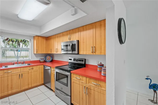 a utility room with stainless steel appliances granite countertop a sink and cabinets
