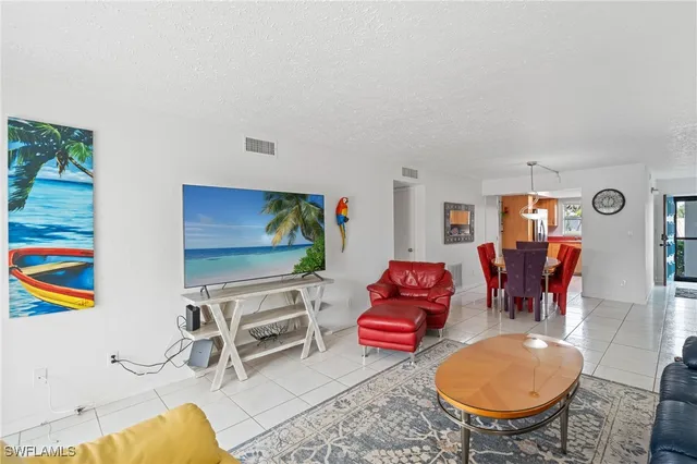 a living room with furniture a rug and a lamp