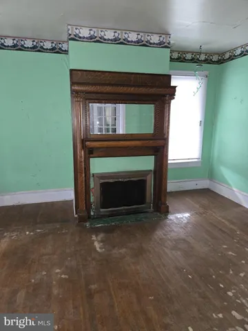 a view of empty room with fireplace and fan