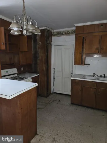 a kitchen with stainless steel appliances a chandelier and a refrigerator