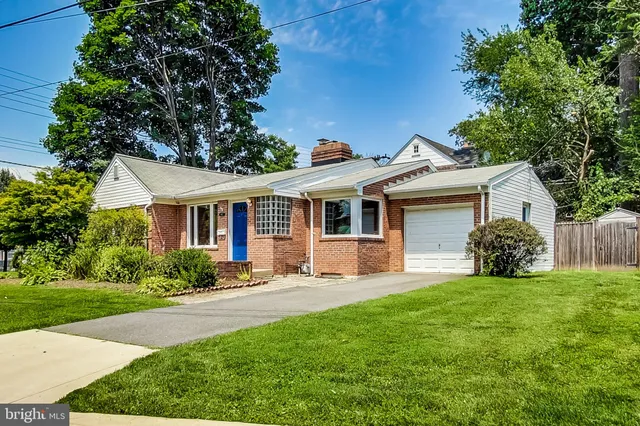 a front view of a house with a garden and yard