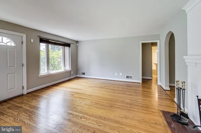 an empty room with wooden floor and a window