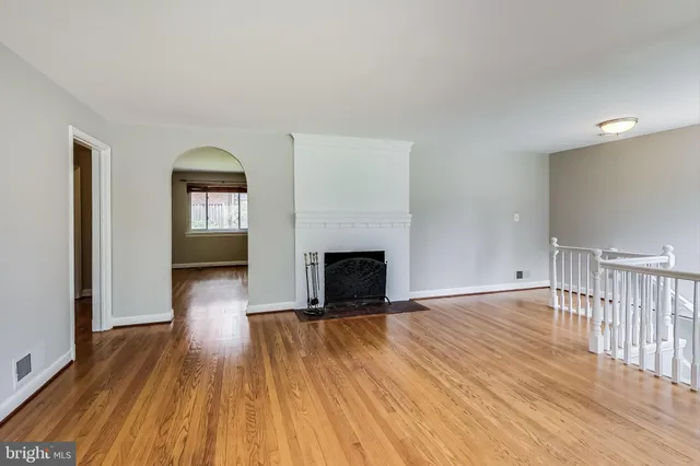 a view of empty room with wooden floor and fireplace