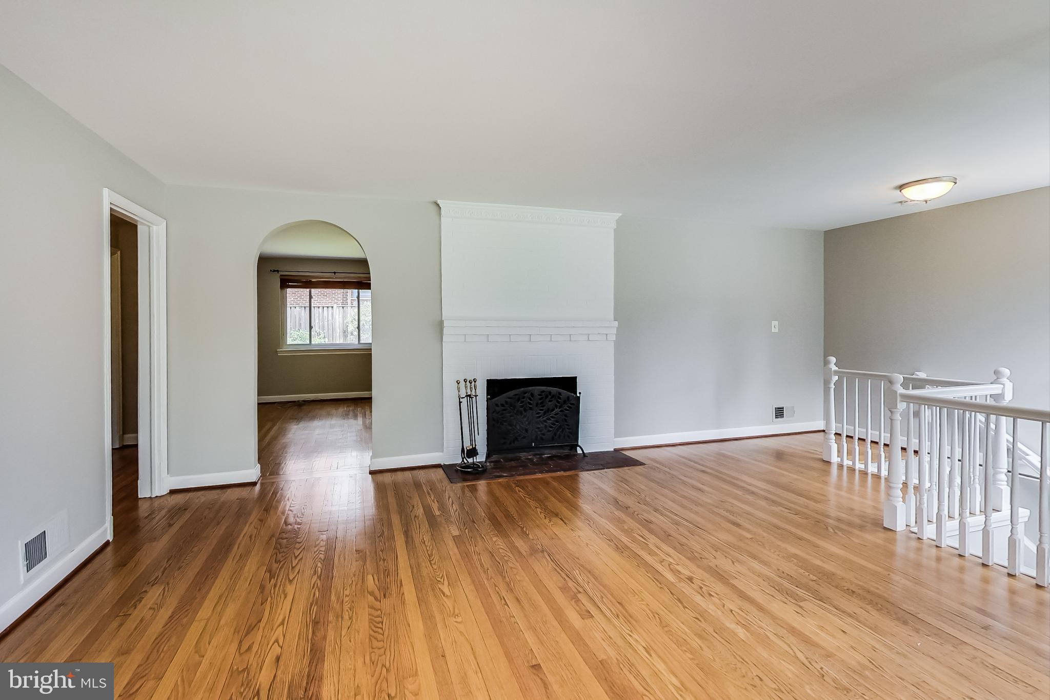 8617 Lynbrook Drive Bethesda, MD 20814 - Photo 15 of 48 a view of empty room with wooden floor and fireplace