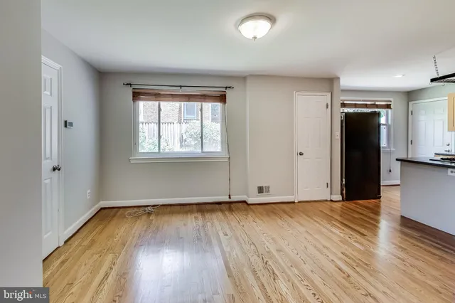an empty room with wooden floor and a window