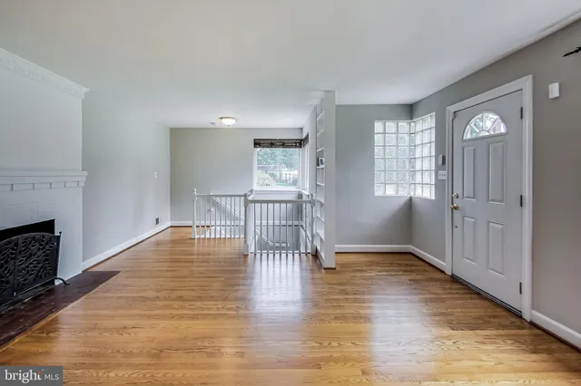 a view of empty room with wooden floor and fireplace