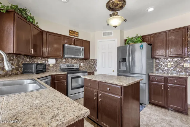 a kitchen with granite countertop a stove top oven cabinetry a sink and granite counter tops