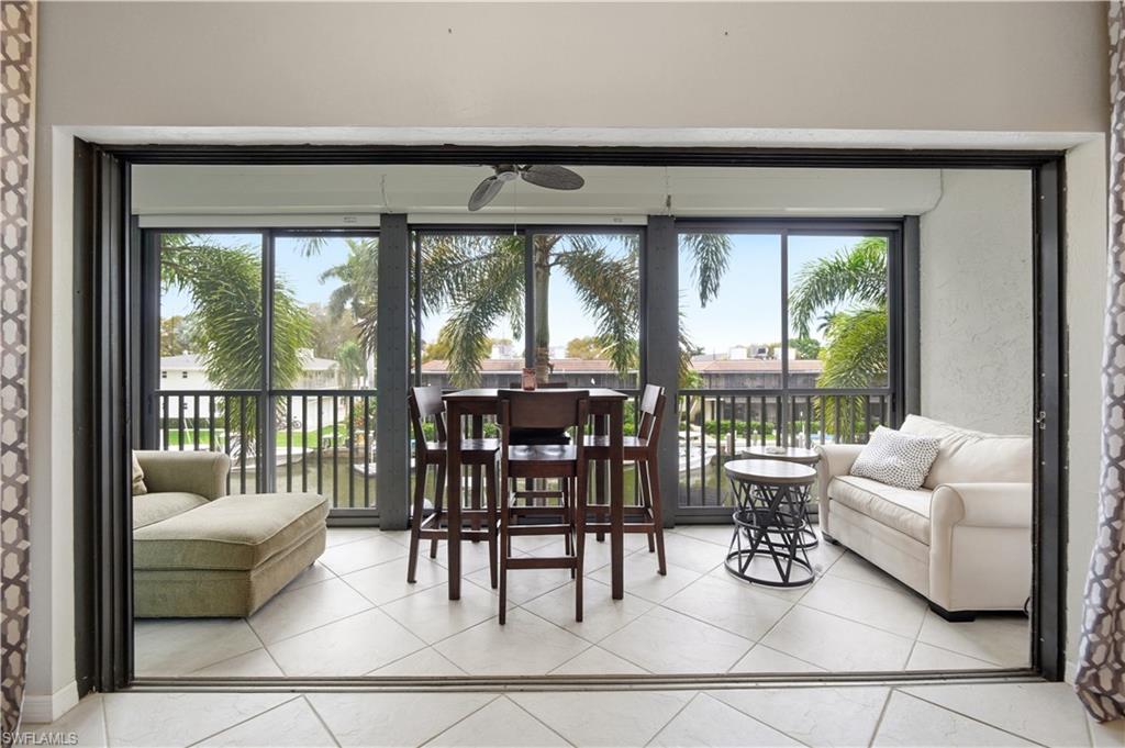 1400 Blue Point Avenue, Unit 206 Naples, FL 34102 - Photo 15 of 19 a living room with furniture and a large window with outer view
