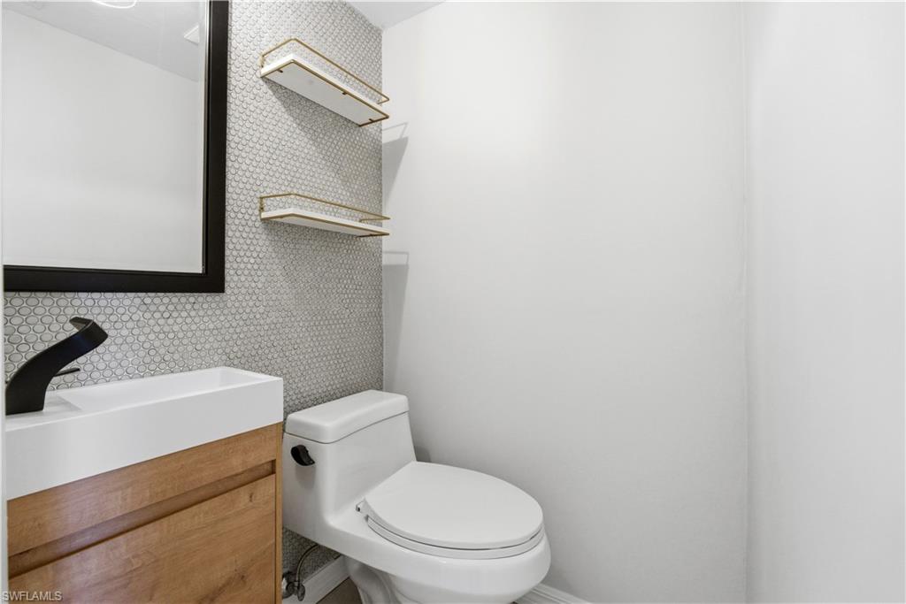 1400 Blue Point Avenue, Unit 206 Naples, FL 34102 - Photo 5 of 19 a white toilet sitting next to a bathroom sink