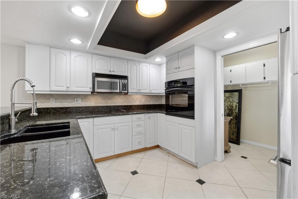 1400 Blue Point Avenue, Unit 206 Naples, FL 34102 - Photo 7 of 19 a kitchen with granite countertop a refrigerator and a stove top oven