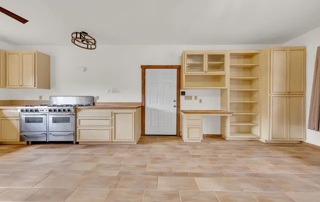 a view of a hallway with wooden floor and a kitchen