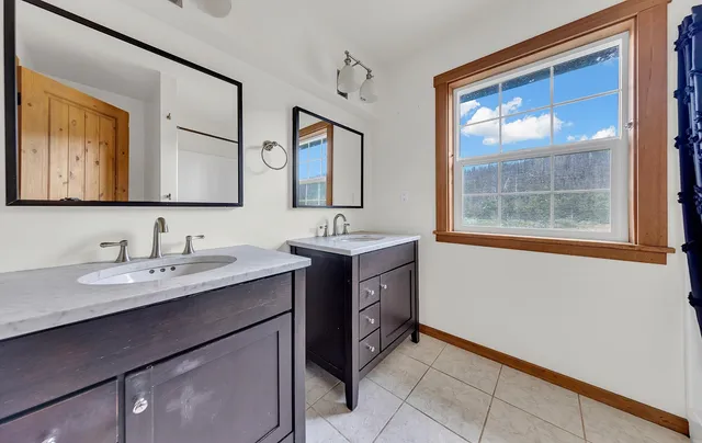 a bedroom with a bed and a dresser next to a window