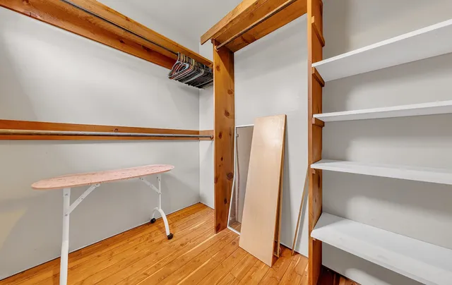 a bed sitting in a spacious bedroom next to a window
