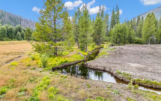 a front view of a house with a yard and lake view