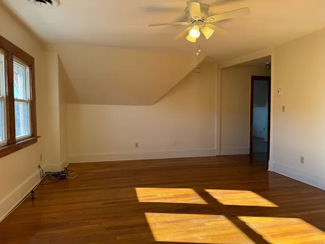a view of an empty room with wooden floor