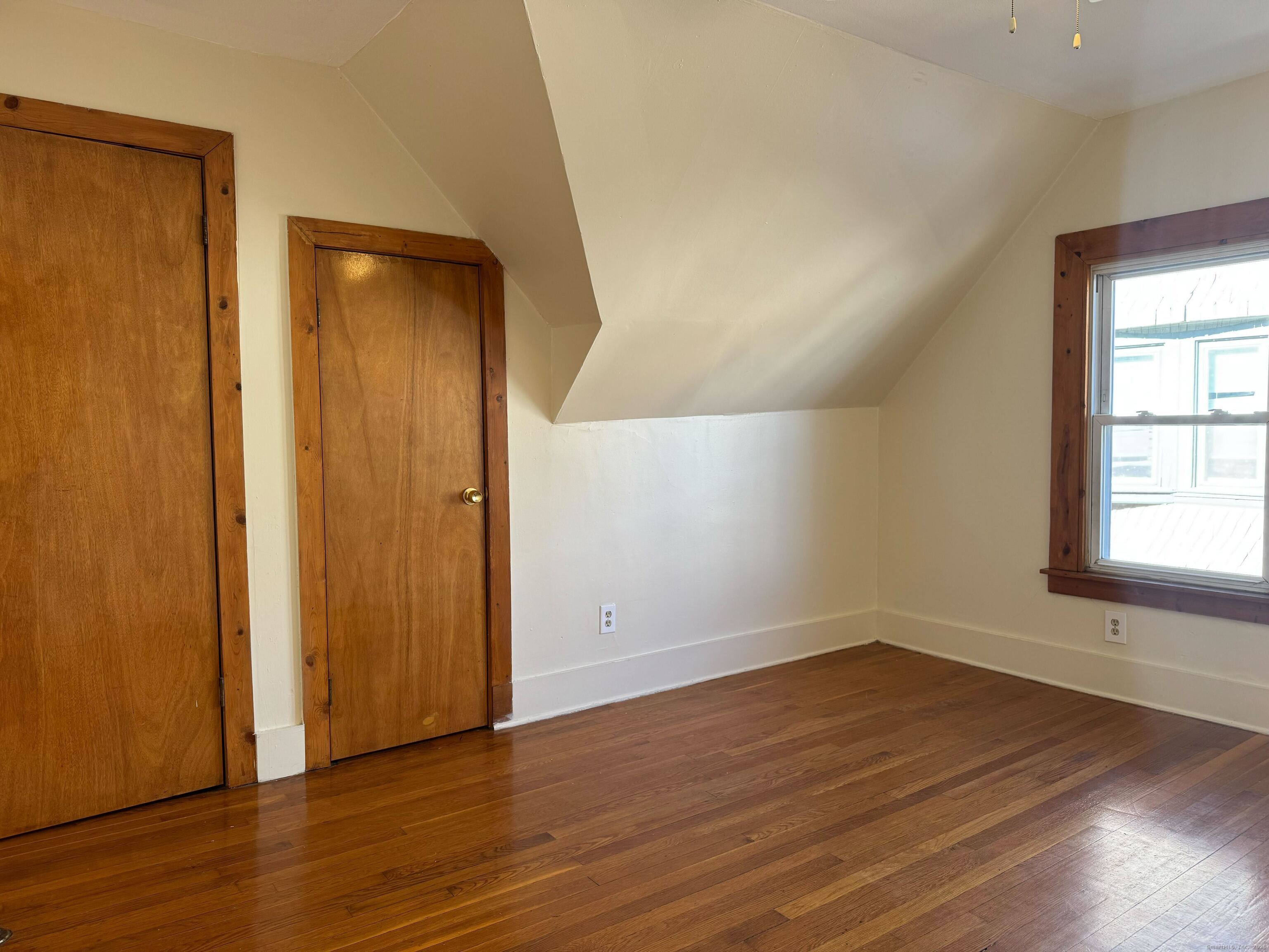 461 Howard Avenue, Unit 3 New Haven, CT 06519 - Photo 9 of 11 an empty room with wooden floor and windows