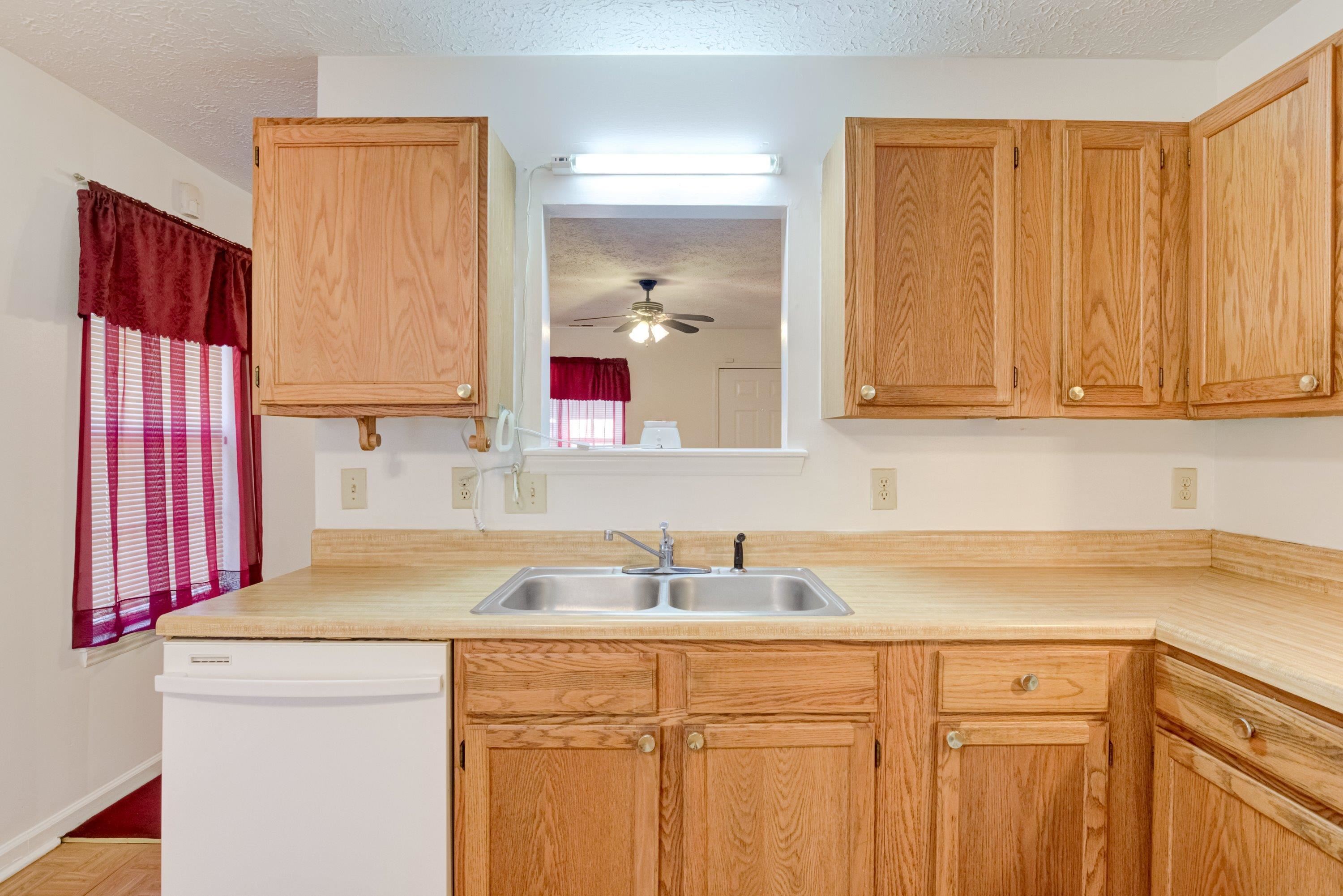5823 Hadrian Drive Durham, NC 27703 - Photo 7 of 20 a kitchen with a sink cabinets and a window