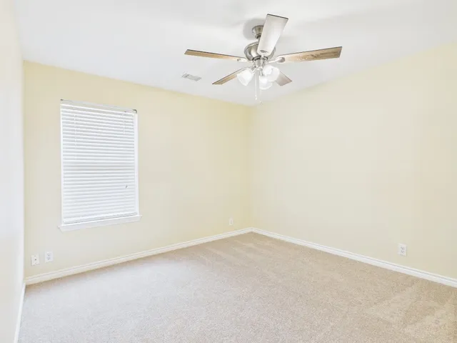 an empty room with a window and a fan