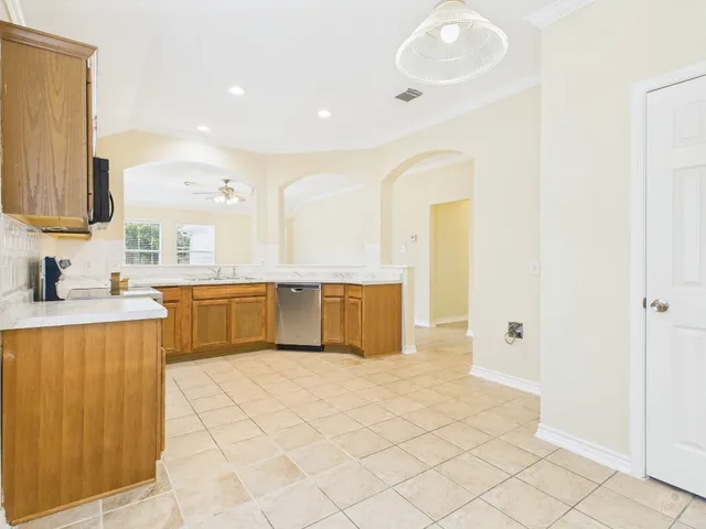 a large white kitchen with a sink a counter top space and cabinets