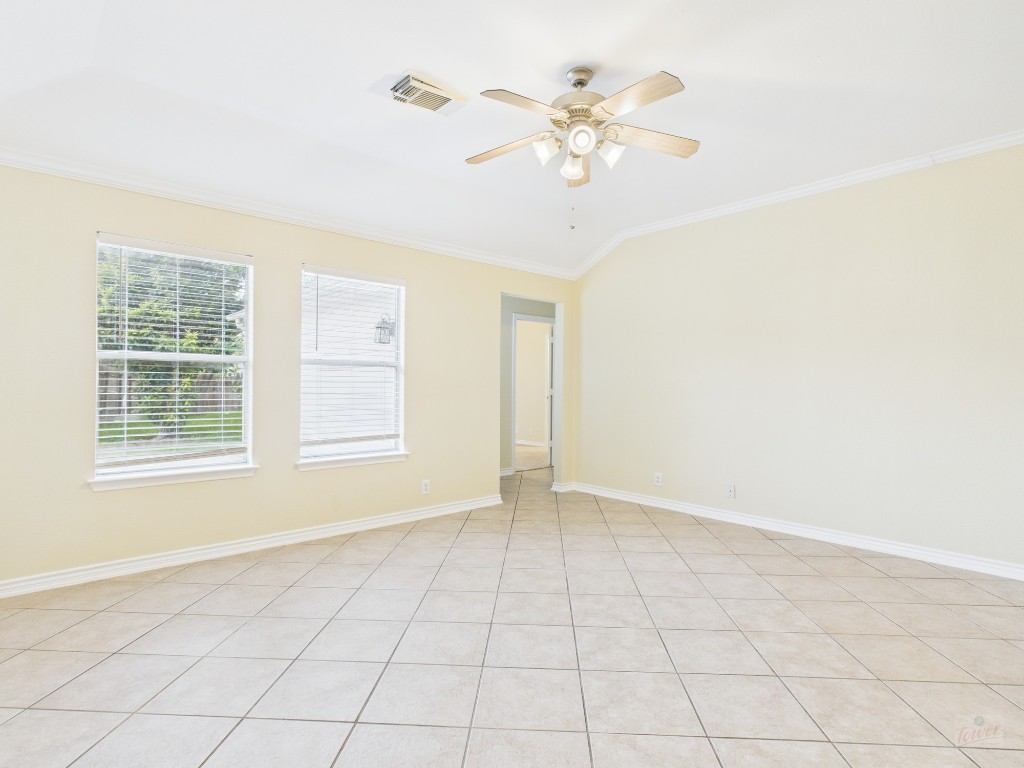 136 Winter Street Kyle, TX 78640 - Photo 10 of 32 an empty room with chandelier fan and windows