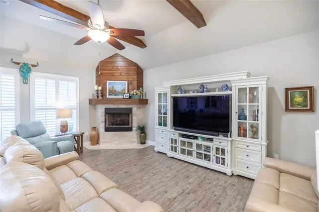 a living room with furniture a flat screen tv and a fireplace