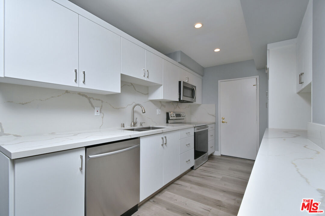 2345 Roscomare Road, Unit 205 Los Angeles, CA 90077 - Photo 17 of 50 a kitchen with sink a microwave and cabinets