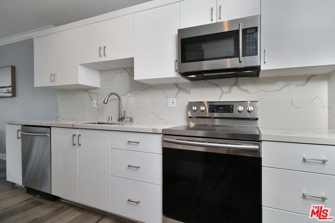 2345 Roscomare Road, Unit 205 Los Angeles, CA 90077 - Photo 19 of 50 a kitchen with stainless steel appliances a stove a microwave a sink and cabinets