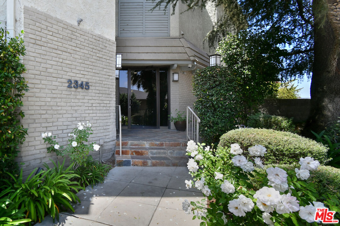 2345 Roscomare Road, Unit 205 Los Angeles, CA 90077 - Photo 2 of 50 a front view of a house with a yard and potted plants