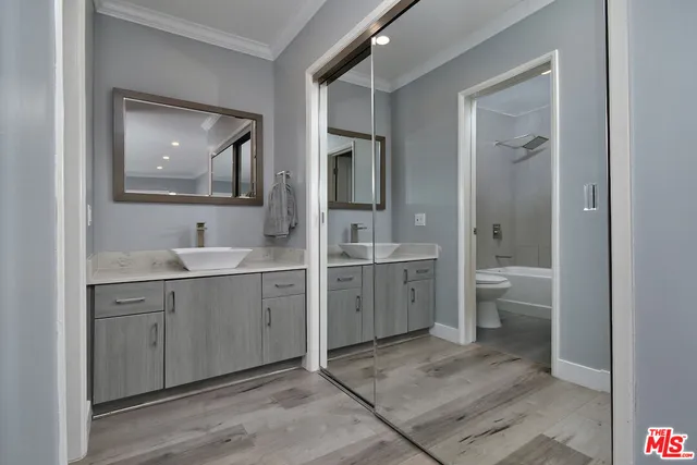 a spacious bathroom with a double vanity sink a toilet and a shower