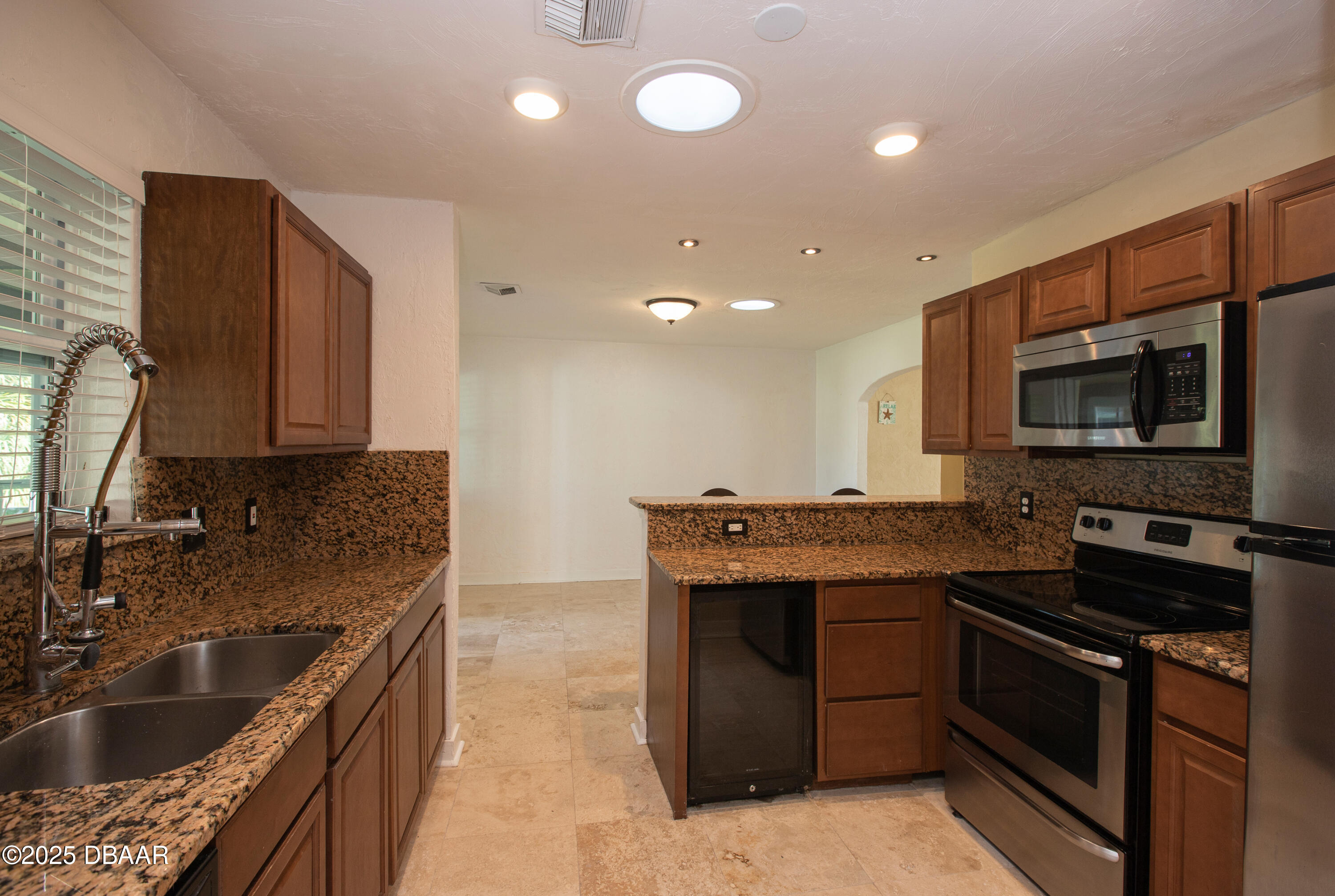 131 Minerva Road Daytona Beach, FL 32118 - Photo 15 of 21 a kitchen with stainless steel appliances granite countertop a sink and a stove top oven with wooden floor