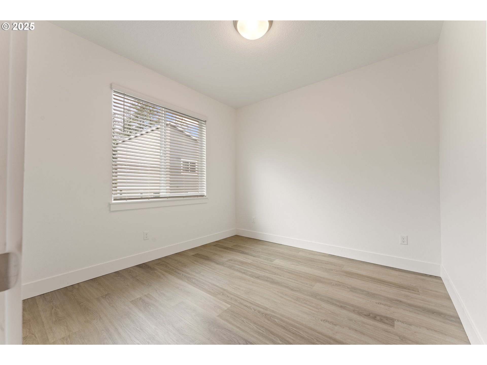 3037 Southwest Sherman Place Beaverton, OR 97003 - Photo 13 of 39 a view of an empty room with wooden floor and a window