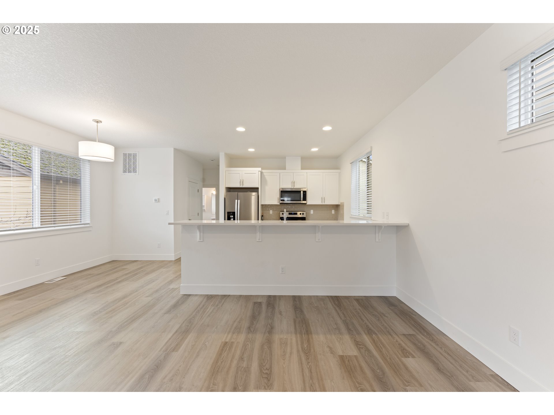 3037 Southwest Sherman Place Beaverton, OR 97003 - Photo 9 of 39 a view of kitchen with kitchen island wooden floor center island and stainless steel appliances