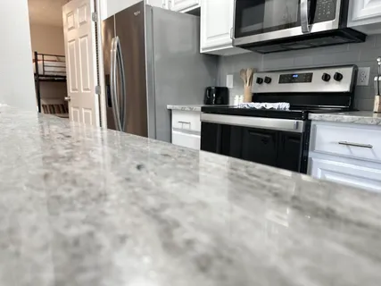 a kitchen with stainless steel appliances granite countertop a stove and a refrigerator