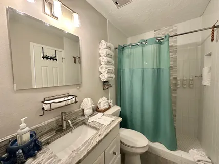a bathroom with a sink toilet and shower