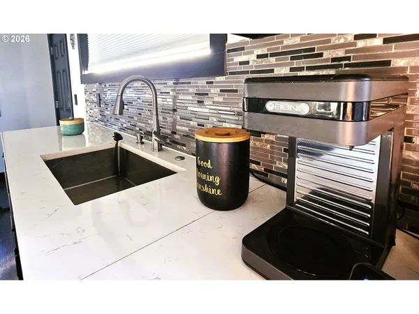 a kitchen with a sink cabinets and wooden floor