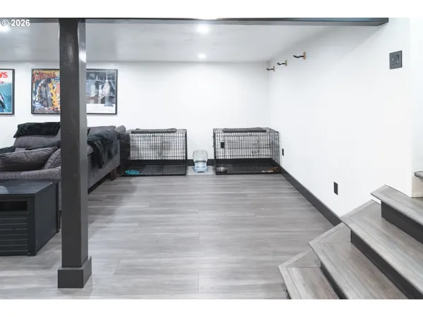 a view of an empty room with wooden floor and a fireplace