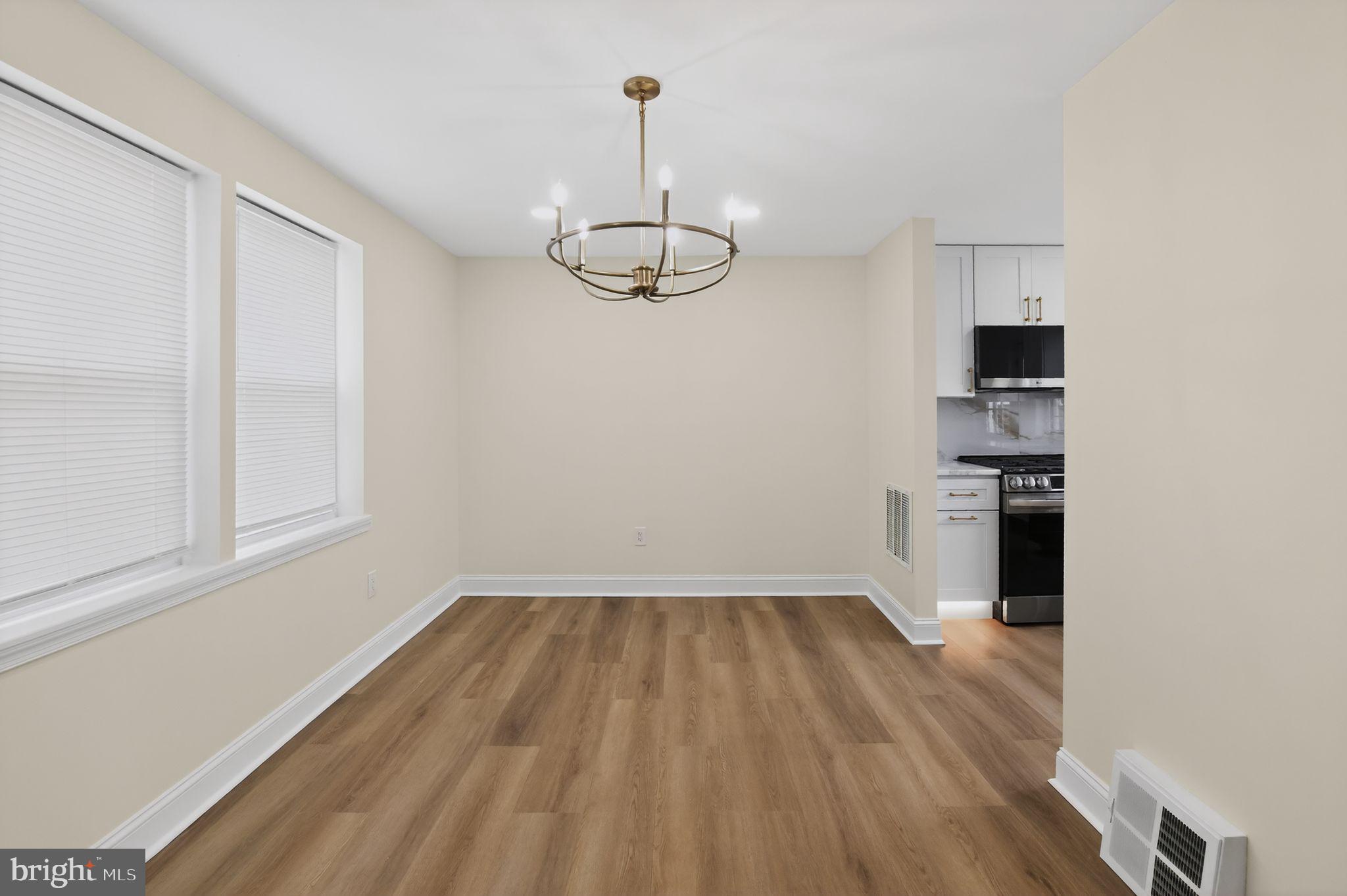 306 Brentwood Road Havertown, PA 19083 - Photo 10 of 48 a view of empty room with wooden floor and kitchen