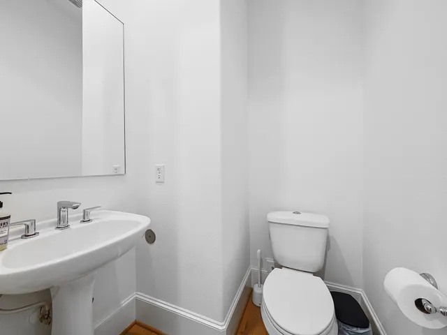 a bathroom with a sink a toilet and a mirror