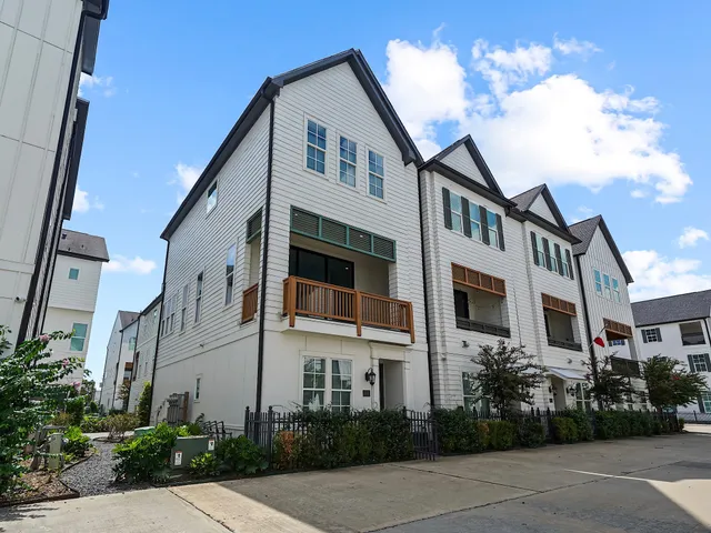 a front view of a multi story residential apartment building with yard and entryway