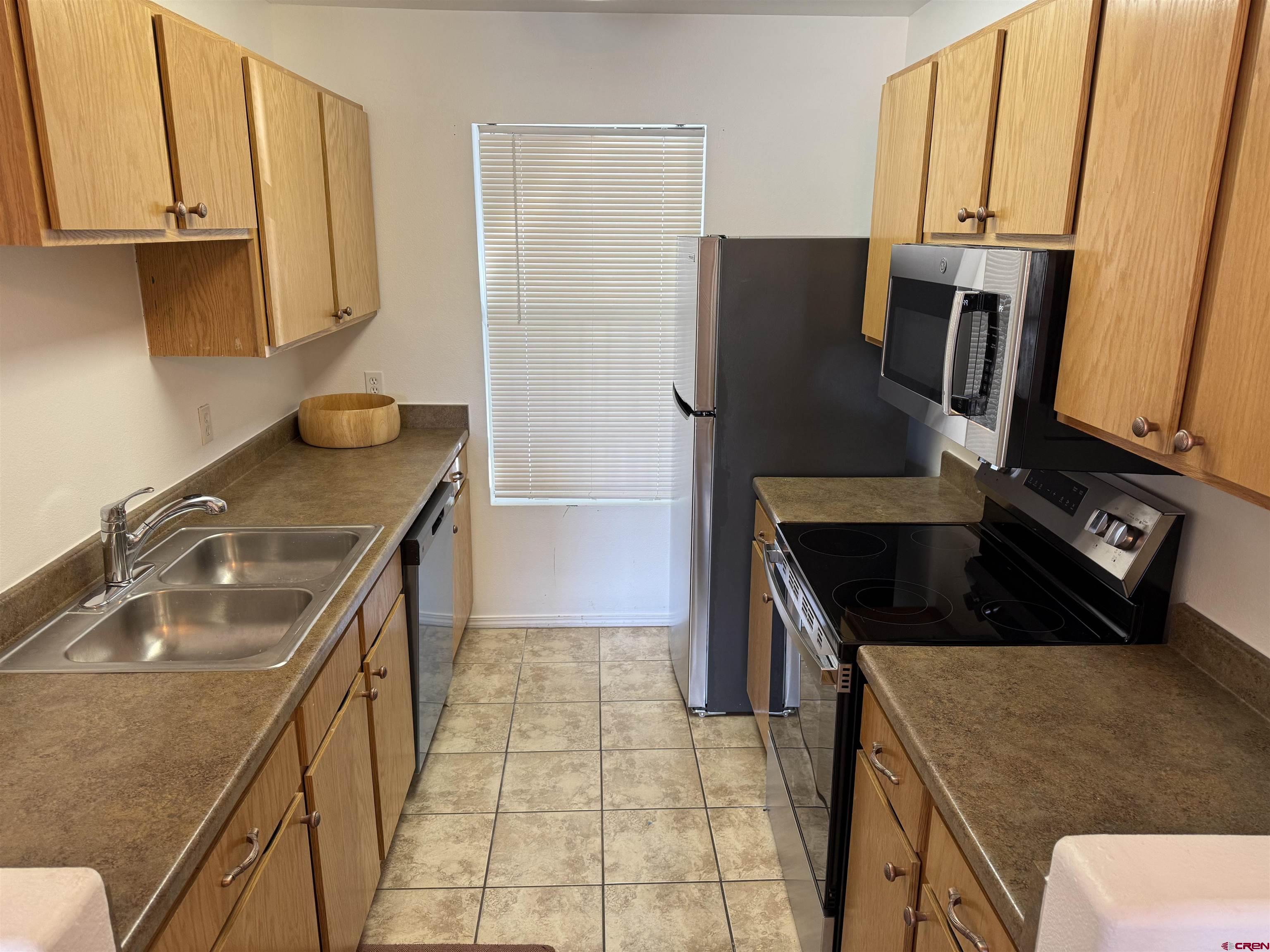 1100 Goeglein Gulch Road, Unit 238 Durango, CO 81301 - Photo 9 of 35 a kitchen with stainless steel appliances granite countertop a sink stove and refrigerator