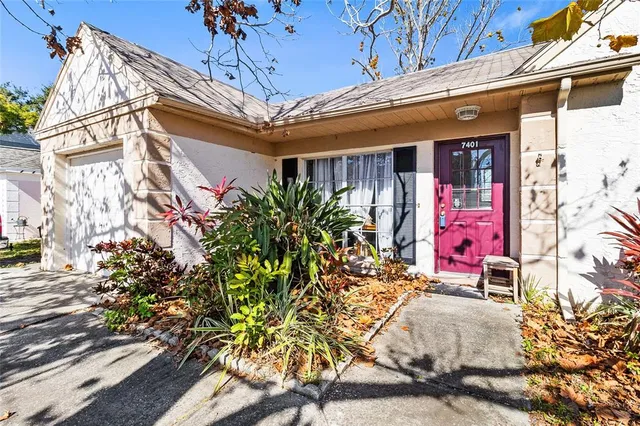 a living room with furniture and a dining table with kitchen appliances