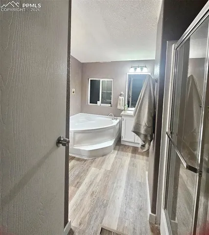 a living room with a bed furniture and a wooden floor