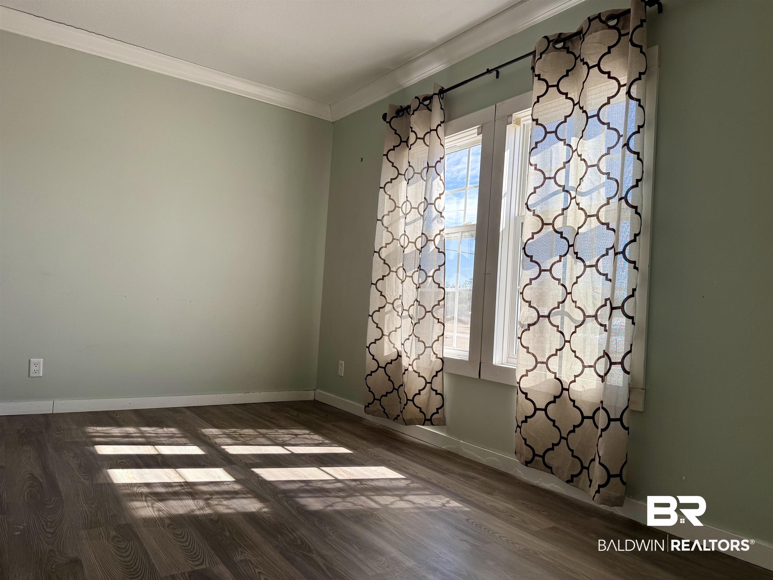 1064 Old Fannie Road Flomaton, AL 36441 - Photo 7 of 17 Spare room featuring crown molding and dark wood finished floors